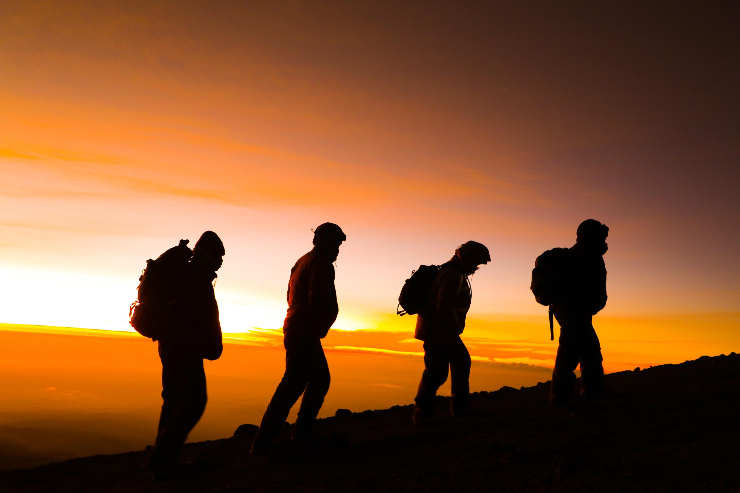 Climbers wearing headlamps and full winter layers on the Kilimanjaro summit night ascent before dawn